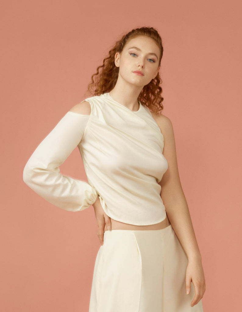 Off white asymmetric draped blouse with cut out belle sleeve on right and sleeveless on the left.
