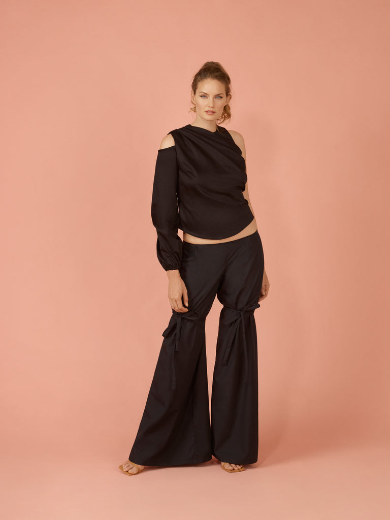 Black asymmetric draped blouse with shoulder cut out on solo belle sleeve