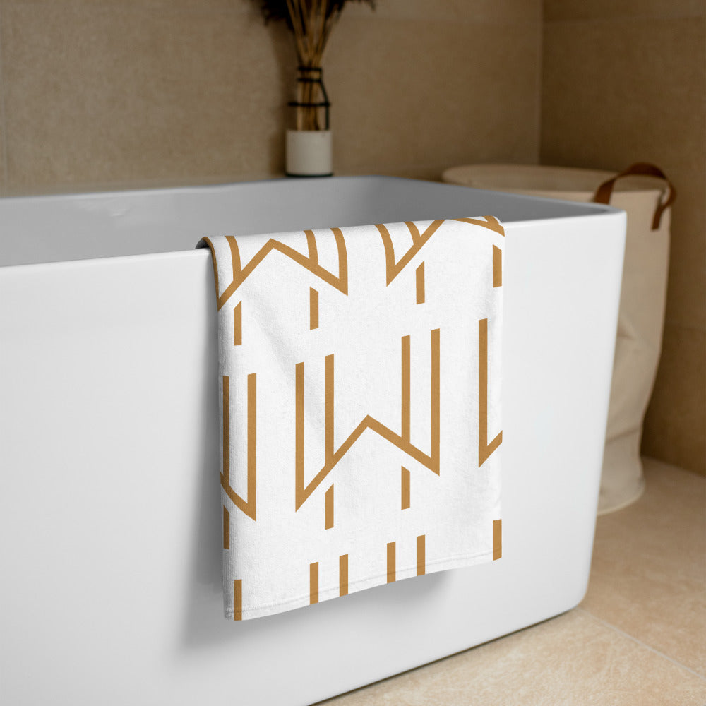 Wadsworth House print branded beach towel folded over a modern bath tub.